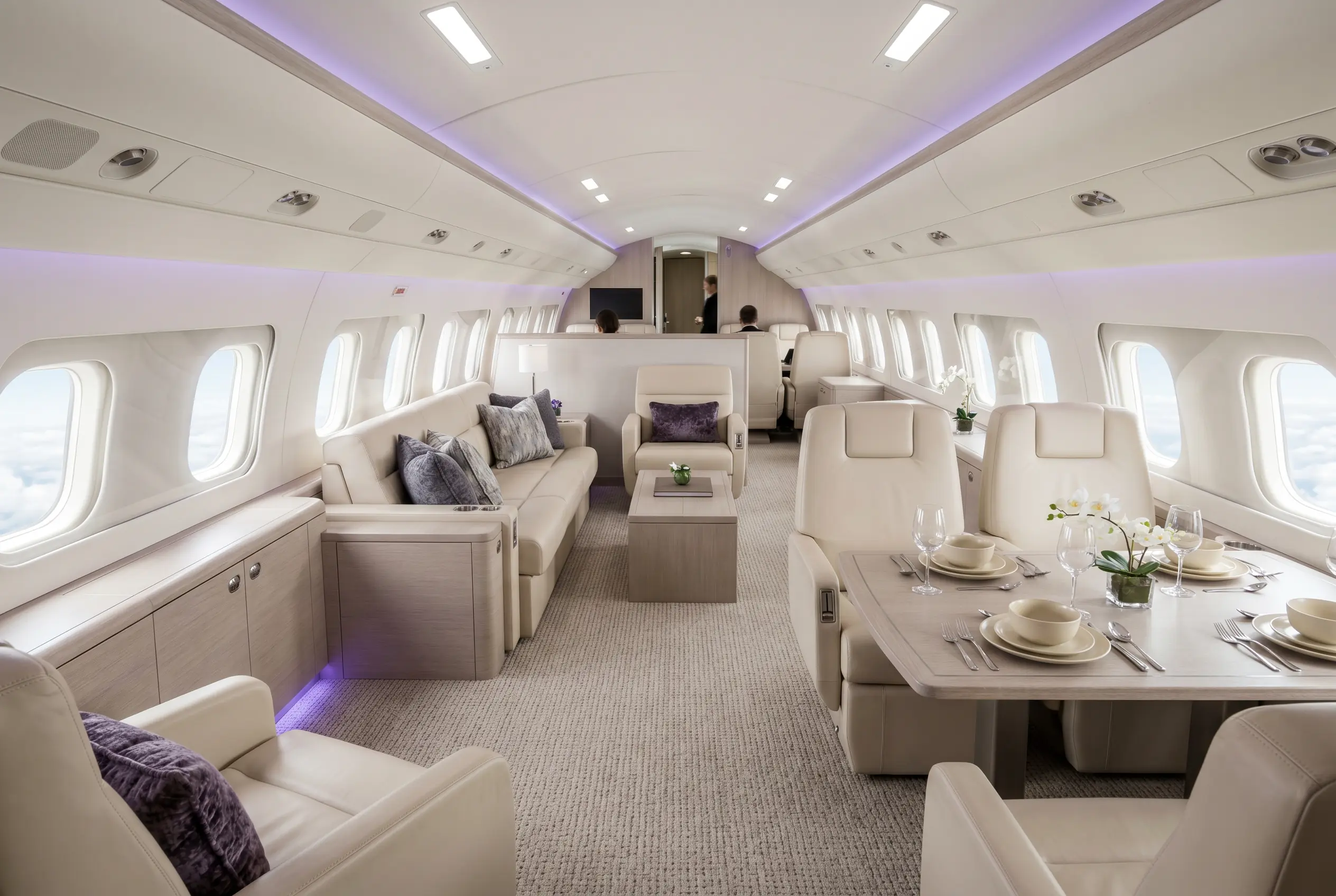 Embraer Lineage 1000E VIP lounge with sofas and a dining area for a Miami to New York charter